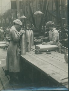 Two women workers inspecting and stamping part-finished shells.
