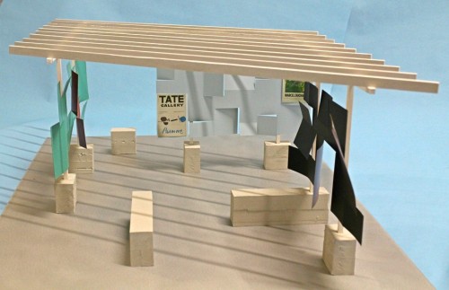 Model open structure with blocksand vertical uprights supporting a roof of crossbeams against blue background