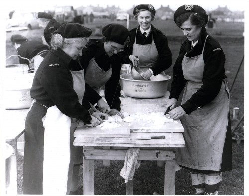 Newcastle Civil Defence volunteers preparing a meal in a camp kitchen