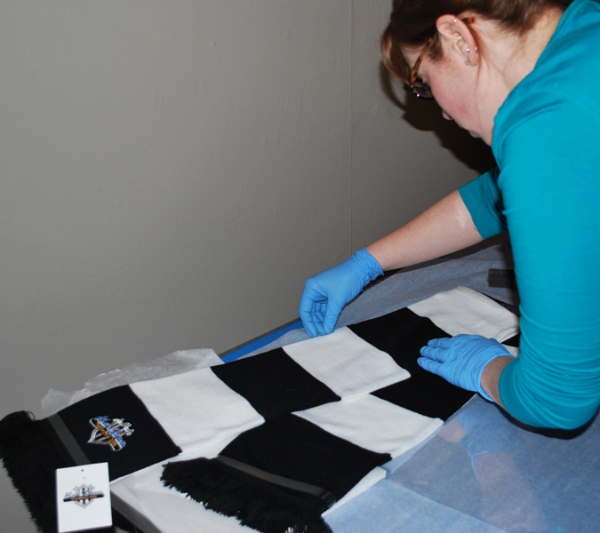 Louise preparing an NUFC scarf to go in a case