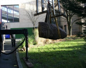 Using a crane to lift the Birney Hill Rock into place.