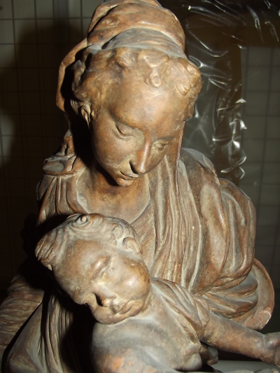 Brown wooden sculpture of woman holding small child