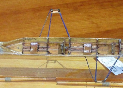 Model of a pair oar c1880 with foot steering fitted for use by the rower in the bow seat. This model has two footed steering controlled by a lever which sits between the feet. The long slides and seats running on wheels suggest that this model was made a few years later than the first appearance of sliding seats on the Tyne in 1871. TWCMS : 1999.215